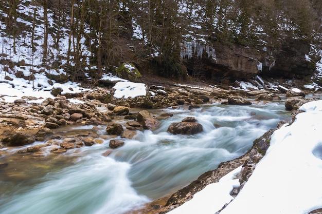 Río en las montañas. área montañosa. foto en un día nublado de larga exposición. cascadas en las montañas en el bosque, paisaje invernal de ríos de montaña