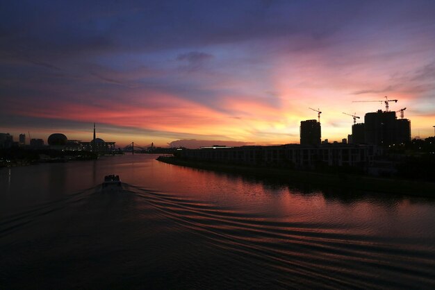 Rio na cidade contra o céu durante o pôr do sol