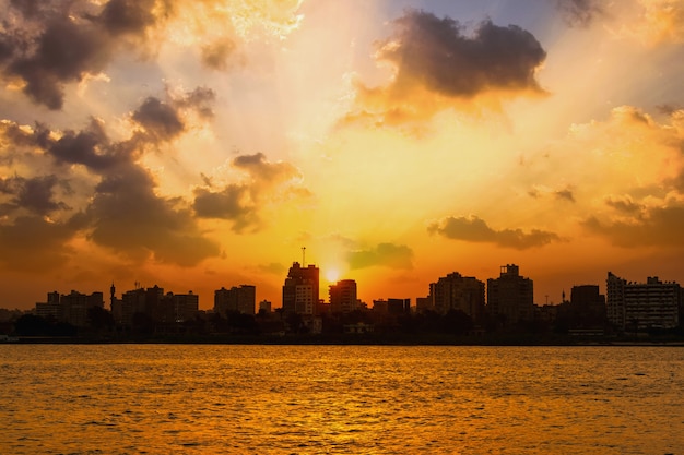 Foto rio nilo, o sol se esconde nos prédios da cidade do cairo