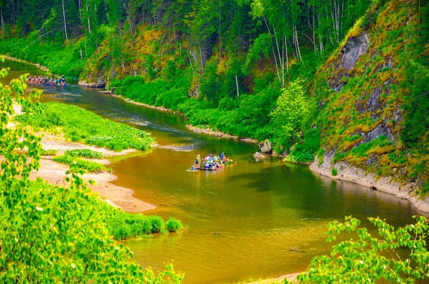 Un río con una orilla verde y un río con gente en él.