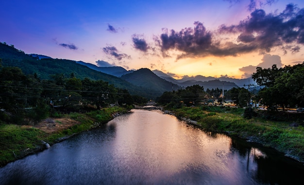 Río piedra y árbol en el atardecer o el amanecer