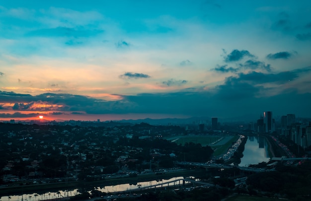 Rio pinheiros cercado por árvores e escritórios.