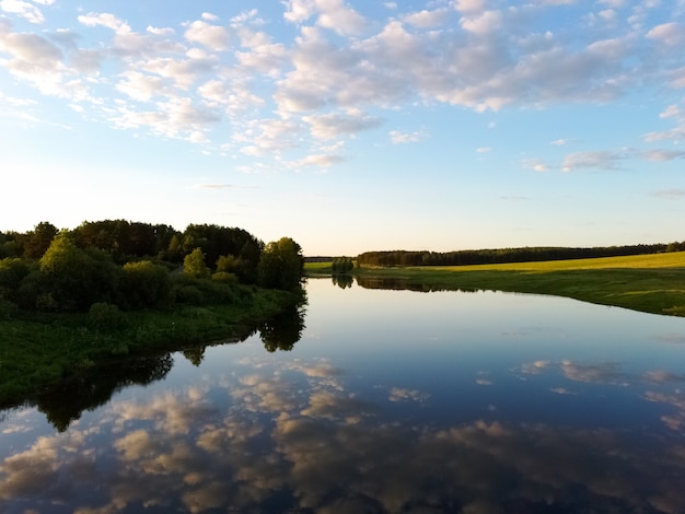 Río con reflejo de nubes en un día de verano al atardecer vista desde un avión no tripulado.