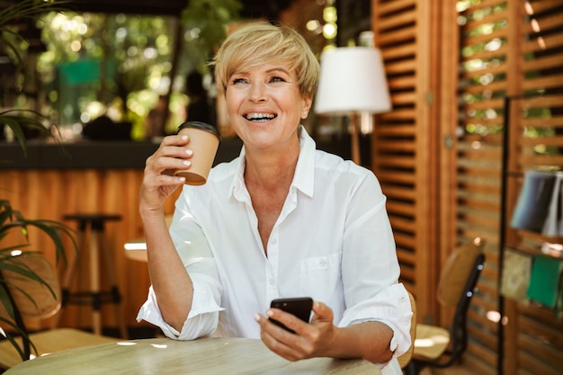 Risa mujer madura con teléfono móvil