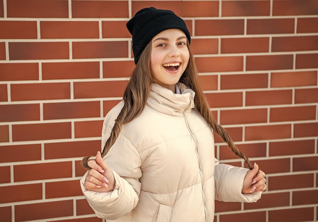 risada adolescente ao ar livre adolescente vestindo chapéu foto de adolescente fora adolescente em fundo de tijolo