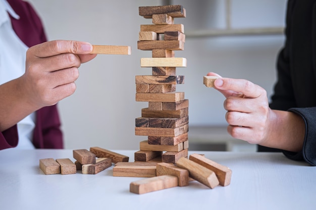 Foto risco e estratégia alternativos nos negócios, mão da equipe de negócios, jogo cooperativo, colocando a hierarquia de blocos de madeira na torre para o planejamento e desenvolvimento colaborativos para obter sucesso