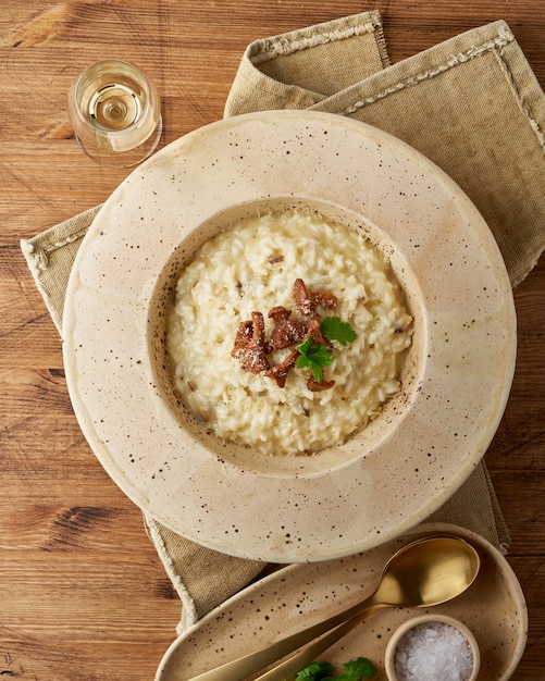 Risoto com cogumelos chanterelle em prato grande. vista superior, vertical