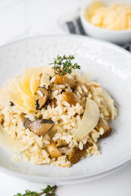 Risoto com cogumelos porcini e parmesão em fundo claro, foco seletivo, close-up