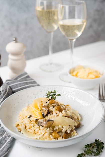 Risoto com cogumelos porcini e parmesão em fundo claro, foco seletivo