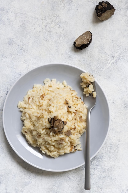 Risoto com cogumelos porcini e trufas negras servidas em um prato gourmet com vista superior