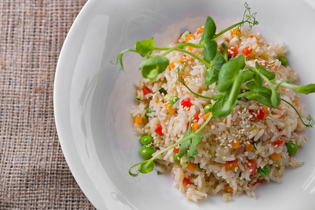 Risoto com legumes e gergelim em um prato branco