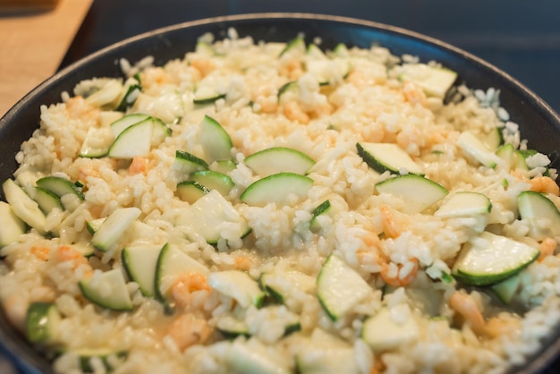 Risoto cremoso com camarão e abóbora em uma frigideira