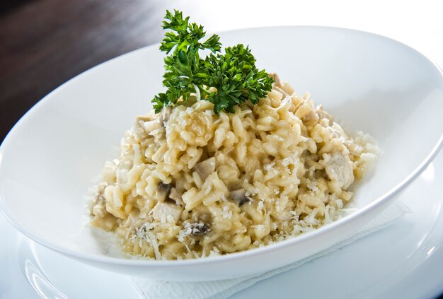 Risoto de arborio de arroz italiano com alho-poró na mesa branca