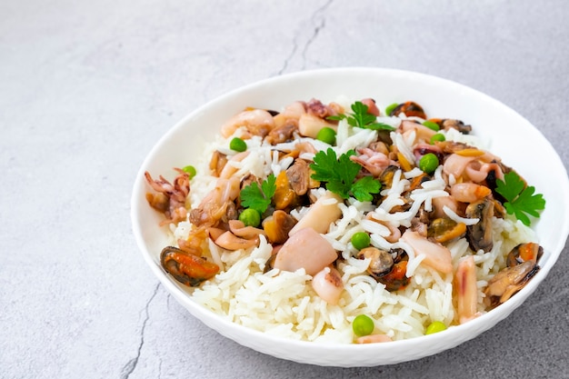 Risoto de frutos do mar em arroz de chapa branca com mexilhões, polvo, lulas, camarões e salsa