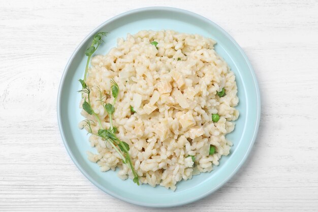 Risoto delicioso com queijo na vista superior da mesa de madeira branca