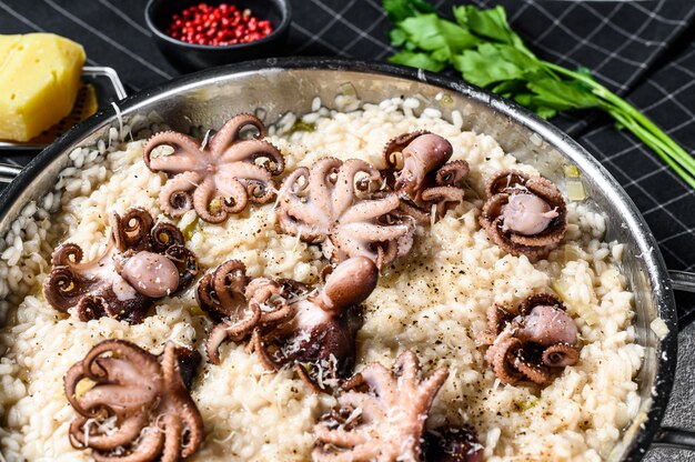 Risoto italiano com polvo e cogumelos, decorado com parmesão e salsa.