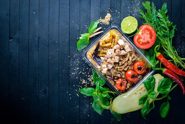 Risotto Arroz con carne y verduras a la parrilla Dieta saludable Comida Almuerzo Boxeo Sobre un fondo de madera negra Vista superior Espacio libre para texto