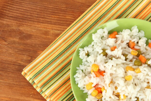 Risotto auf farbiger Platte auf hölzern Hintergrund