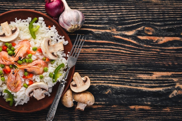 Risotto con camarones y verduras Mariscos Cocina asiática Sobre un fondo de textura de madera Vista superior Espacio libre