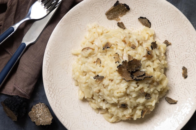 Risotto con champiñones porcini y trufas negras servido en un plato vista superior cocina gourmet