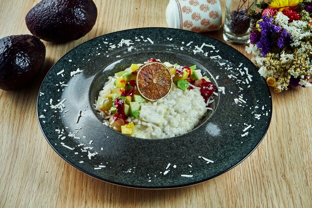 Risotto mit Parmesan, Blauschimmelkäse und Avocado in einer Schüssel auf einem Holztisch. Italienisches Essen. Gourmet Essen. Gesundes Essen. Nahansicht