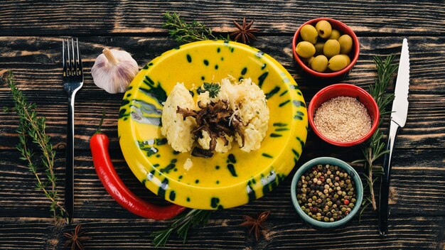 Risotto mit Pilzen garnieren Draufsicht auf schwarzem Holzhintergrund Kopierbereich