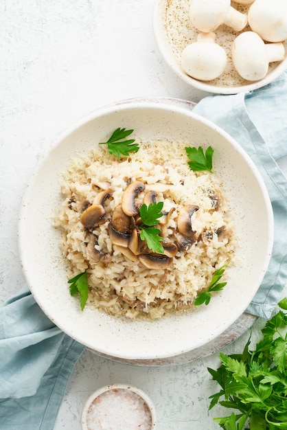 Risotto mit Pilzen in Teller. Reisbrei mit Pilzen und Petersilie