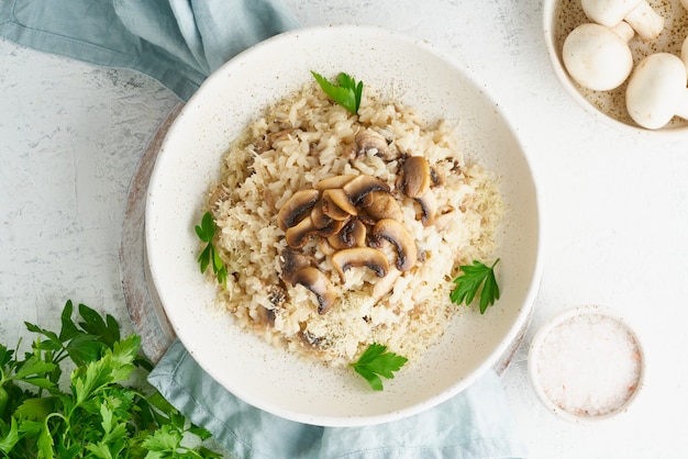 Risotto mit Pilzen in Teller. Reisbrei mit Pilzen und Petersilie