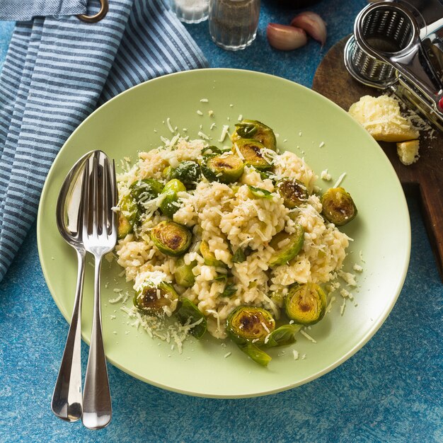 Risotto de primavera italiano con coles de Bruselas y queso parmesano sobre la mesa.