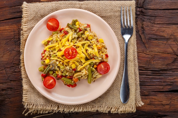 Risotto con setas en un plato sobre un fondo de madera sobre una servilleta de lino y un tenedor.