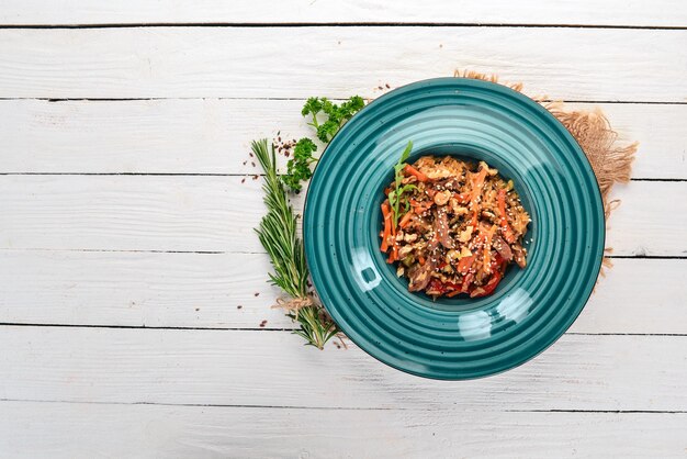 Risotto con ternera y verduras Sobre un fondo de madera Cocina china Vista superior Espacio de copia