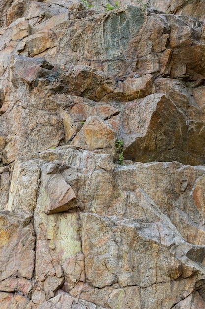 Risse im Granitgestein durch menschliche Aktivität. Zerstörung des Granitfelsens des Berges nach der Explosion. Konzept der Umweltprobleme