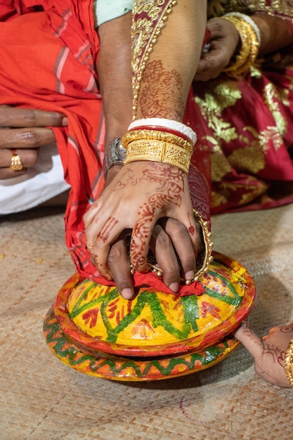 Rituais de casamento tradicionais hindus decoração closeup shot Noiva e noivo de mãos dadas em uma panela de barro decorada Ritual de cerimônia de casamento de hinduísmo Lindo casal hindu de mãos dadas