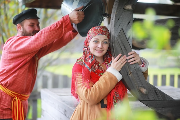 Rituais eslavos tradicionais em estilo rústico. Ao ar livre no verão. Fazenda de aldeia eslava. Camponeses com vestes elegantes.