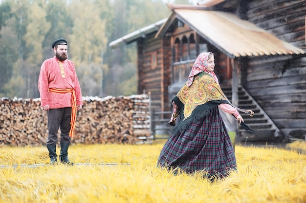 Rituais eslavos tradicionais em estilo rústico. Ao ar livre no verão. Fazenda de aldeia eslava. Camponeses com vestes elegantes.