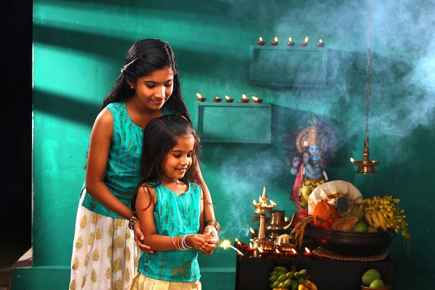 Rituales del festival de Kerala del festival de Vishu y dos niños celebrando quemando la bengala