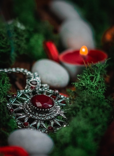 Rituelle Amulett grüne Mooskerze getrocknete Blumen und Steine in Baumrinde auf Schwarz