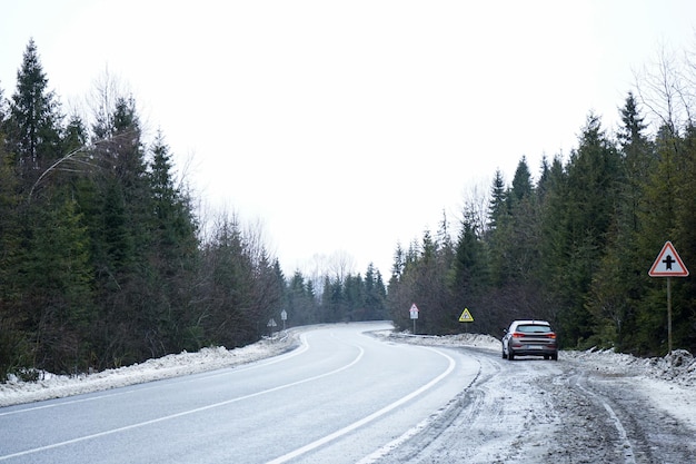 Road Trip Concept Car en una carretera de invierno en el bosque