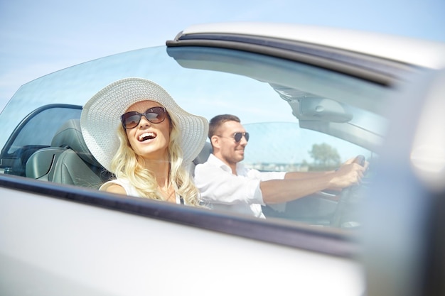 Foto road trip, reise, dating, paar und personenkonzept - glücklicher mann und frau, die draußen im cabrioletauto fahren