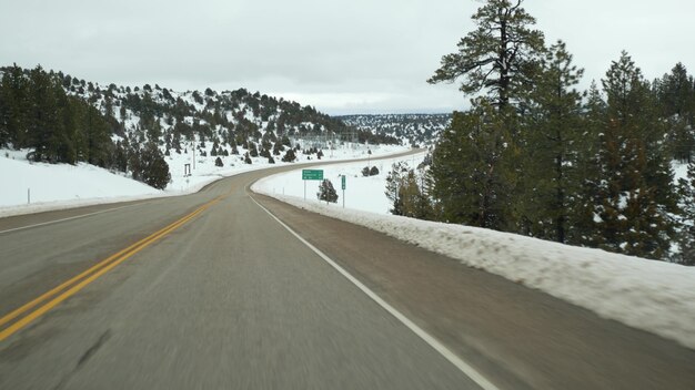 Roadtrip in den USA von Zion nach Bryce Canyon Autofahren in Utah Trampen Reisen in Amerika Route zum Dixie Forest Winter lokale Reise ruhige Atmosphäre und Schneeberge Blick vom Auto