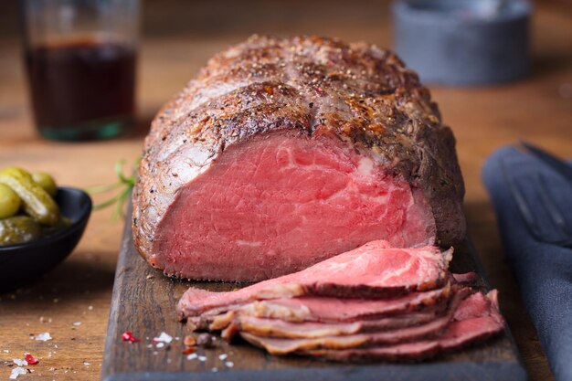 Roast beef sobre tabla de cortar Fondo de madera