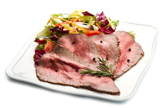 Roastbeef auf weißem Teller mit Salat