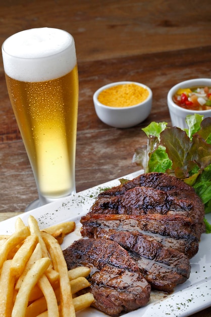 Roastbeef mit Kartoffeln und Salat und einem Glas Bier