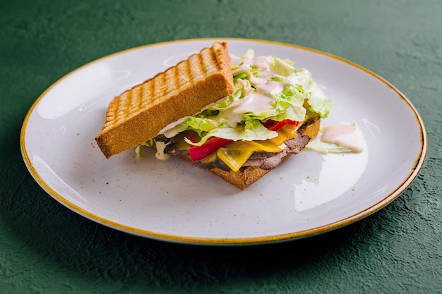 Roastbeef preparado servido con verduras y hierbas sobre una tostada de pan