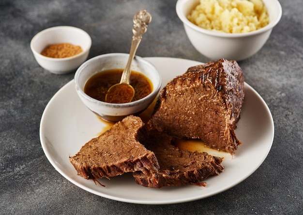 Roastbeef Rindergulasch in Scheiben geschnittenes gebratenes Stück Rindfleisch mit Sauce auf einem Teller