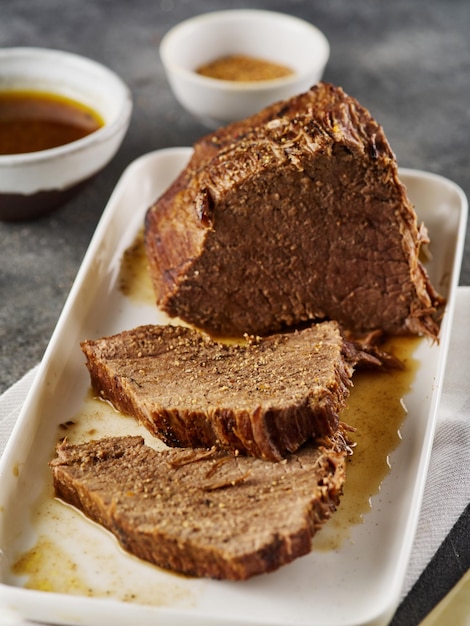 Roastbeef Rindergulasch in Scheiben geschnittenes gebratenes Stück Rindfleisch mit Sauce auf einem Teller