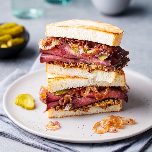 Roastbeef-Sandwich auf einem Teller mit Essiggurken