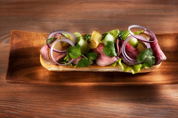 Roastbeef-Sandwich mit Salat und Gemüse auf einem Holztisch