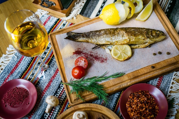 Robalo de peixe assado com especiarias de peixe, vinho e salada. frutos do mar assados em restaurante alimentação saudável