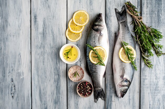 Robalo de peixe fresco. Robalo peixe cru com ingredientes especiarias e ervas em fundo de madeira